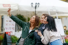 Três amigas tirando uma selfie na rua